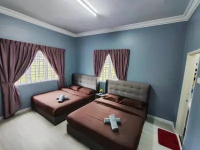 two beds in a bedroom with two crosses on them at A One Holiday Apartment - PRO in Tanah Rata