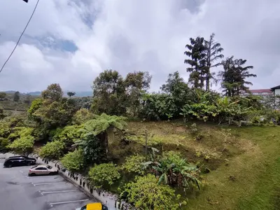 a hill with cars parked in a parking lot at A One Holiday Apartment - PRO in Tanah Rata
