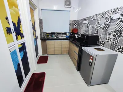 a kitchen with a sink and a refrigerator at A One Holiday Apartment - PRO in Tanah Rata