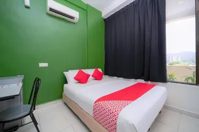 a bedroom with a bed with red and green walls at Hotel O My Budget Home in Batu Ferringhi