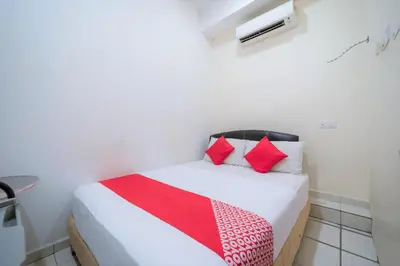 a bedroom with a bed with red pillows at Hotel O My Budget Home in Batu Ferringhi