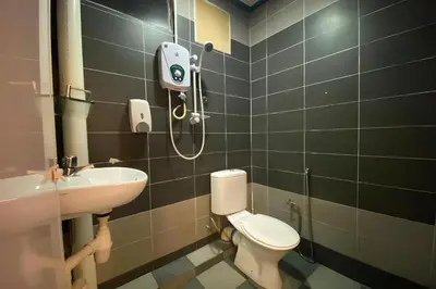 a bathroom with a toilet and a sink at Hotel O My Budget Home in Batu Ferringhi