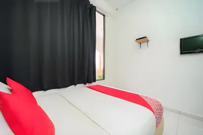 a bedroom with a bed with red pillows and a window at Hotel O My Budget Home in Batu Ferringhi