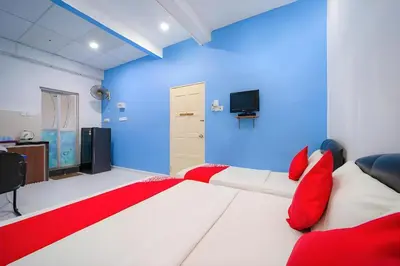 a bedroom with a large white bed with red pillows at Hotel O My Budget Home in Batu Ferringhi