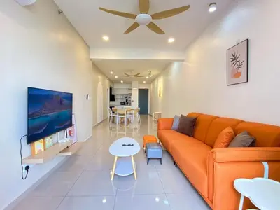 a living room with an orange couch and a table at JOVIAL Modern Cozy Suite `Metropol BM BandarPerda in Bukit Mertajam
