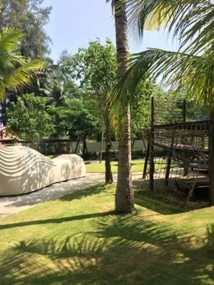 a park with a playground with a slide and palm trees at By The Sea@Sunset view and Seaview #32 in Batu Ferringhi