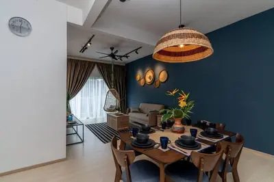 a living room with a table and a blue wall at Highland Green at Quintet (3BR/ 8pax) in Tanah Rata