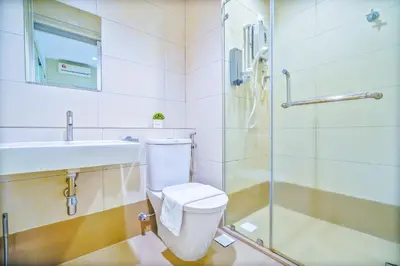 a bathroom with a toilet and a sink and a shower at The Octagon Ipoh -- In the Heart of the City in Ipoh