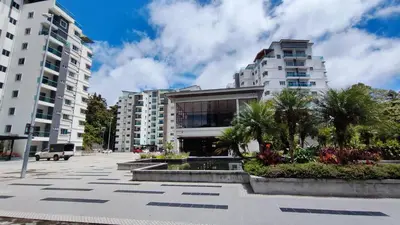 a building with a fountain and palm trees in front of it at A ONE Holiday Apartment-Quintet in Cameron Highlands