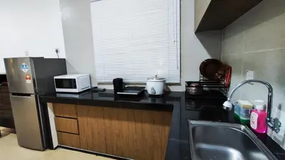 a kitchen with a counter top with a microwave and a refrigerator at A ONE Holiday Apartment-Quintet in Cameron Highlands