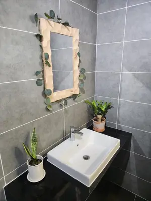 a bathroom sink with a mirror and potted plants at Unique Boho Style Condo with NETFLIX for up to 5PAX - Enjoy Mountain View while swimming at the Infinity Pool & Natural Hotspring Pool, 2mins walk to the Lost World of Tambun, Water Themepark at IPOH in Ipoh