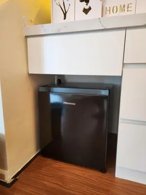 a microwave sitting under a desk in a room at Unique Boho Style Condo with NETFLIX for up to 5PAX - Enjoy Mountain View while swimming at the Infinity Pool & Natural Hotspring Pool, 2mins walk to the Lost World of Tambun, Water Themepark at IPOH in Ipoh