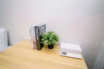 a table with books and a clock and a plant at Swing & Pillows - Penang Road, Georgetown Penang in George Town