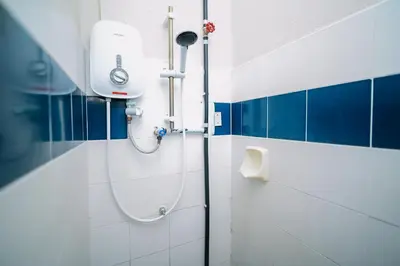 a shower in a bathroom with blue and white tiles at Swing & Pillows - Penang Road, Georgetown Penang in George Town