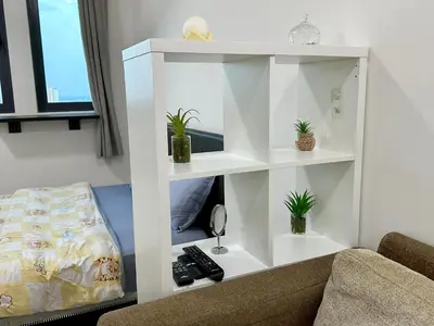 a white book shelf in a living room with a couch at Dreamy Cozy Studio Meritus Residensi Perai in Perai