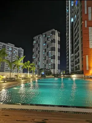 a large swimming pool at night with tall buildings at Dreamy Cozy Studio Meritus Residensi Perai in Perai