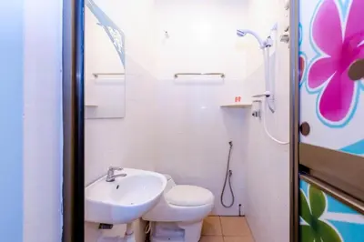 a white bathroom with a toilet and a sink at Spring Inn Hotel in Sungai Petani