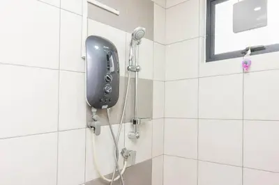 a shower with a black phone on the wall at Suites Bayan Lepas in Bayan Lepas