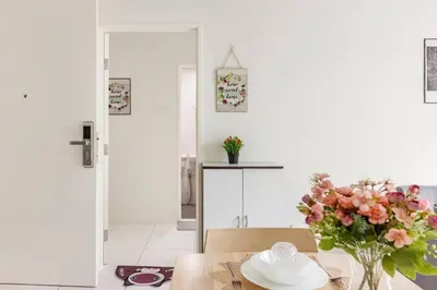 a dining room with a table with a vase of flowers at Suites Bayan Lepas in Bayan Lepas