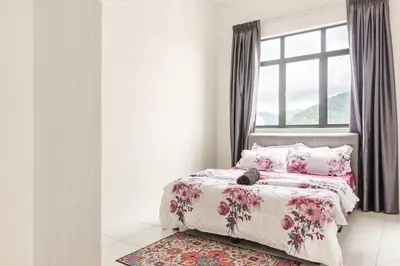 a bedroom with a bed with a cat laying on it at Suites Bayan Lepas in Bayan Lepas