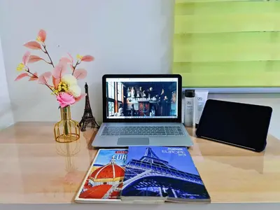 a laptop computer sitting on a desk with a book at Cozy n Quiet home near to BKE Highway n Kulim High Tech Park in Lunas