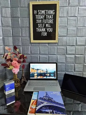 a desk with a laptop and a poster on the wall at Cozy n Quiet home near to BKE Highway n Kulim High Tech Park in Lunas