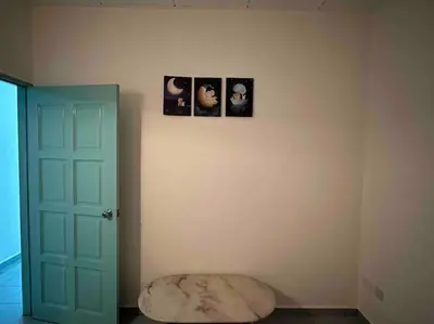 a room with a blue door and pictures on the wall at AAA Homestay Georgetown Penang in Ayer Itam