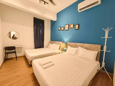 a bedroom with two beds and a blue wall at Ipoh The Cove Hillside Stay 7 to 10 pax, 5 min to Ipoh Town in Ipoh