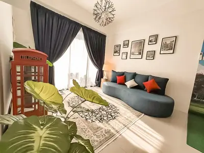 a living room with a blue couch and a plant at Ipoh The Cove Hillside Stay 7 to 10 pax, 5 min to Ipoh Town in Ipoh