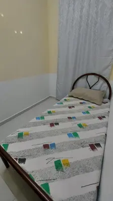 a bed with a quilt on top of it at SEROJA HOMESTAY in Baling