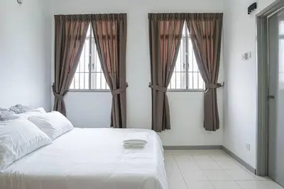 a bedroom with a white bed and two windows at Jovial Modern Stylish Townhouse 8pax - BM Icon City in Bukit Mertajam