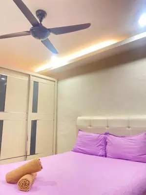 a bed with purple pillows and a ceiling fan at Modern Stylish Double Storey 5Room 9Pax @Icon city in Bukit Mertajam