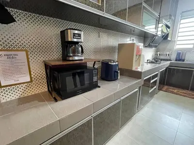 a kitchen with a counter with a microwave and a coffee maker at Cozy Stay At Raintown Taiping in Kamunting