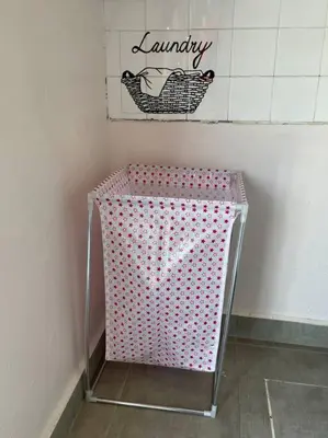 a pink basket in a bathroom with a sign on the wall at Cozy Stay At Raintown Taiping in Kamunting