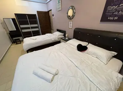 a room with two beds with towels on them at Cozy Stay At Raintown Taiping in Kamunting