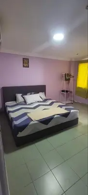 a bedroom with a bed with a blue and white blanket at FAMILY HOTEL in Kuala Kubu Baharu