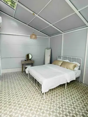 a bedroom with a bed and a table at British Granny's Cottage in Georgetown in Jelutong