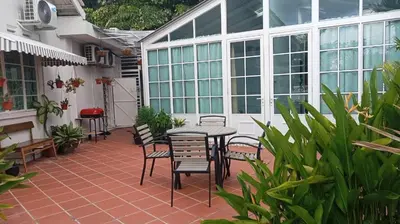 a patio with a table and chairs and windows at British Granny's Cottage in Georgetown in Jelutong