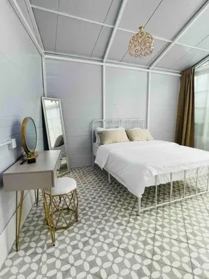 a bedroom with a bed and a table and a mirror at British Granny's Cottage in Georgetown in Jelutong