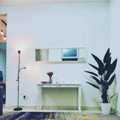 a white room with a table and a plant at Rumah Singgah Bagan Serai Perak in Bagan Serai