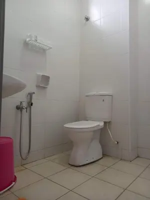 a white bathroom with a toilet and a sink at Rumah Singgah Bagan Serai Perak in Bagan Serai