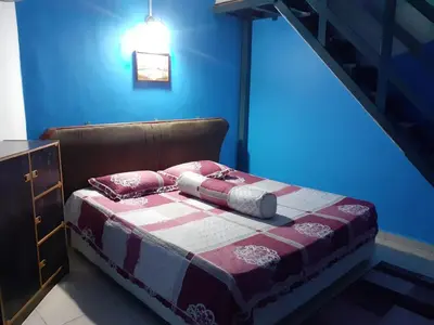 a bed in a room with a blue wall at D'tasek Homestay Gua Musang in Gua Musang