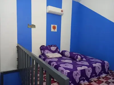 a bed in a room with a blue wall at D'tasek Homestay Gua Musang in Gua Musang