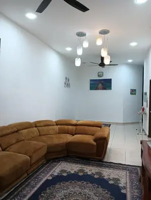 a living room with a brown couch and a rug at D'tasek Homestay Gua Musang in Gua Musang