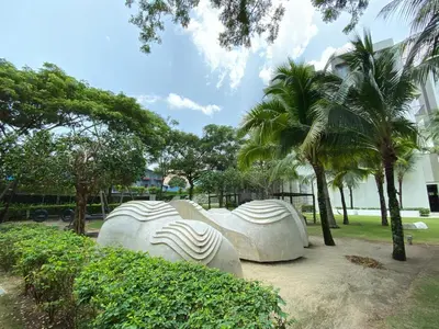 a group of white sculptures in a park with palm trees at By The Sea Cozy Beachfront Home Side Seaview333A in Batu Ferringhi