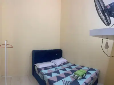 a small bedroom with a bed with blue and white sheets at Homestay Cikgu Mokhsin (Muslim) in Kuala Kangsar