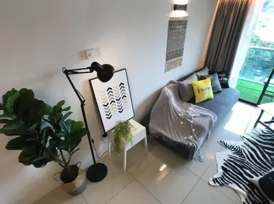 a living room with a couch and a plant at THR339 Kinta Riverfront Suites -6pax in Ipoh