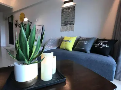 a living room with a couch and a plant on a table at THR339 Kinta Riverfront Suites -6pax in Ipoh