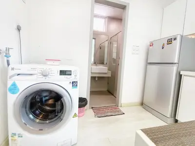 a kitchen with a washing machine and a refrigerator at Deluxe suites 3, 1BR, 2-5 pax, Netflix, Georgetown in George Town