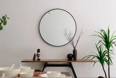 a table with a mirror on a white wall at Serene Mossy Family Cottage(2-7pax) 10 Min to BOH in Cameron Highlands